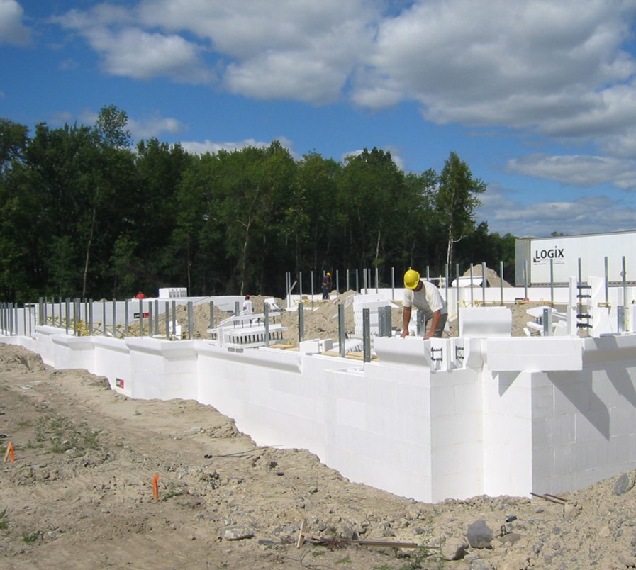 The Kelowna Ready Mix team prepares Logix Insulated Concrete Forms at a construction site on a sunny day.